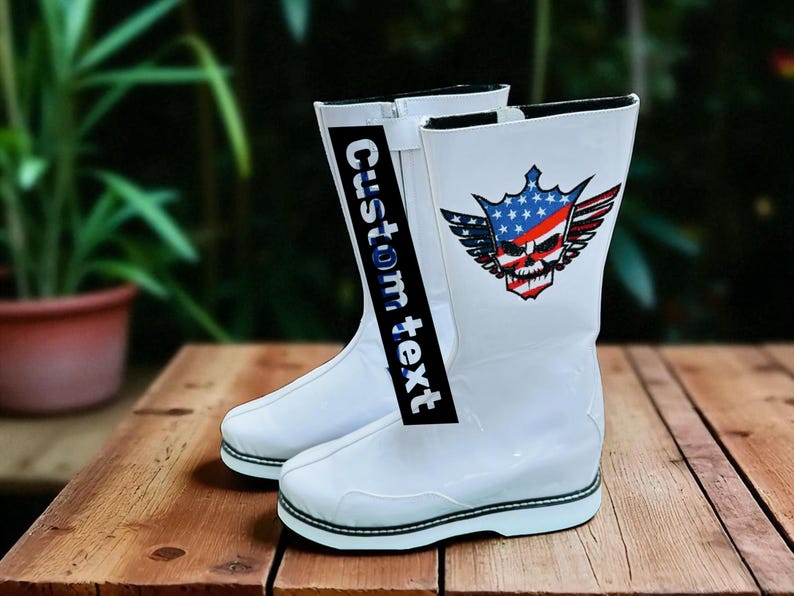 May include: A pair of white boots with a black and white sole. The boots have a graphic of a skull with a crown, wings, and an American flag design. The text "Custom text" is printed on a black strip.