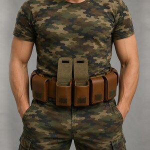 May include: A brown leather utility belt featuring multiple rectangular pouches with flap closures. Two central pouches are shown with their flaps open, revealing the interior, while the remaining pouches along the belt are closed.