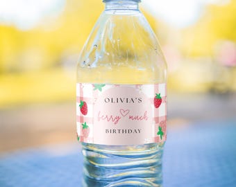 Puede incluir: Una etiqueta de botella de agua rosa y blanca con un patrón de cuadros y fresas. La etiqueta dice "Olivia's Berry Much Birthday".