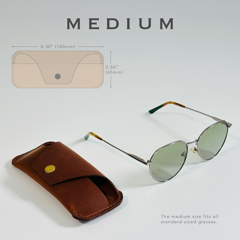 K&ouml;nnte beinhalten: Ein braunes Leder-Brillenetui mit einem goldenen Knopfverschluss. Das Etui ist 16 cm lang und 6,5 cm breit. Der Text "MEDIUM" wird oben im Bild angezeigt. Der Text "Die mittlere Gr&ouml;&szlig;e passt f&uuml;r alle Brillen in Standardgr&ouml;&szlig;e." wird unten im Bild angezeigt.