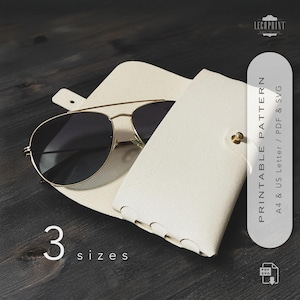 Könnte beinhalten: Sonnenbrille mit goldenem Rahmen und dunklen Gläsern in einem offenen, cremefarbenen Lederetui. Das Etui wird mit einem goldenen Druckknopf verschlossen. Der Text "3 Größen" und "Printable Pattern" ist ebenfalls zu sehen.