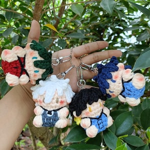 Puede incluir: Colección de cinco llaveros de personajes de ganchillo. Cada llavero presenta un diseño de personaje único con diferentes colores de cabello, atuendos y expresiones faciales. Los llaveros están sujetos a cierres y cadenas de metal plateado.