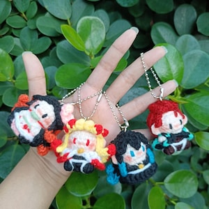 May include: A collection of colourful crocheted character keyrings. Each keyring showcases a distinct character design with detailed facial features and clothing. The keyrings are attached to silver ball chains, ideal for bags or keys.