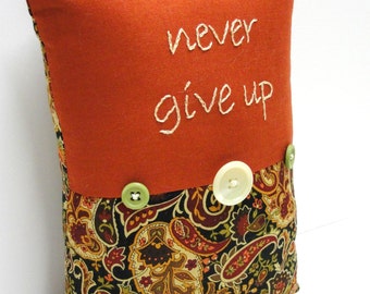 hand-embroidered pillow - "never give up" on rust with black paisley and buttons, Ready to ship