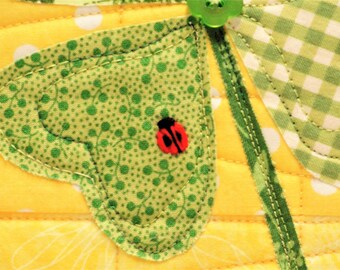 St. Patrick's Day wall quilt with four leaf clover and hand-embroidered ladybug on bright yellow "LUCKY"