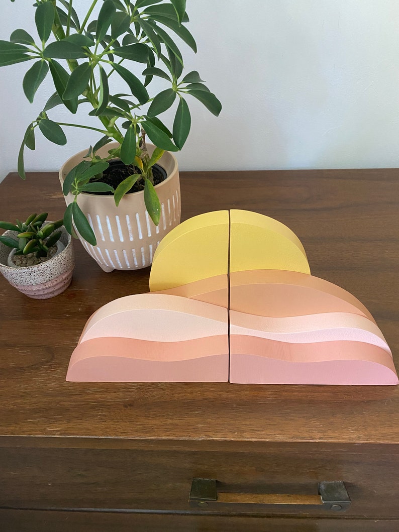 wooden desert landscape with sun sitting on dark walnut desk with plant