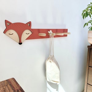 Fox Hook on white wall with plant