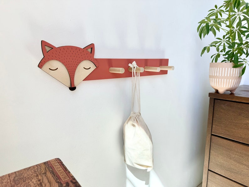 Fox Hook on white wall with plant