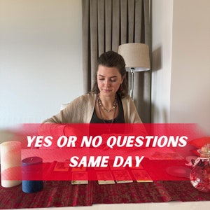 May include: A woman sits at a table with tarot cards laid out. The table is covered with a red cloth and has candles and a decorative glass jar. Text on a red banner reads "YES OR NO QUESTIONS SAME DAY."