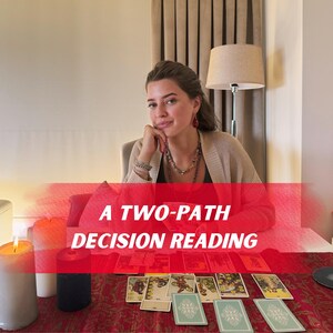 May include: A Two-Path Decision Reading is displayed on a table with tarot cards. The image features a woman, candles, and a lamp. The text "A Two-Path Decision Reading" is overlaid on the image in a red banner.