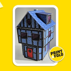 May include: A blue and black paper model of a house with a red door and windows. The model is labeled "PRINT & FOLD".