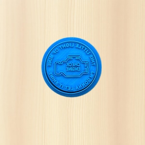 May include: A white ceramic mug with a black handle and the text "But First, Coffee" in a bold, black font. The mug is set against a neutral background, highlighting its simple design.