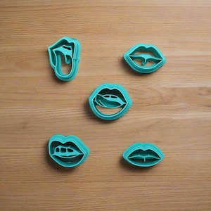 Peut inclure: Ensemble de cinq emporte-pièces en plastique bleu sarcelle en forme de lèvres et de langues.