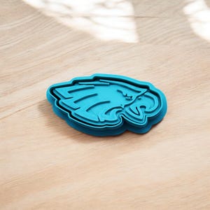 May include: Blue plastic cookie cutter shaped like an eagle's head.