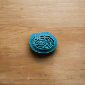 Könnte beinhalten: Teelblauer Plastik-Ausstecher in Form eines Alligator-Kopfes.