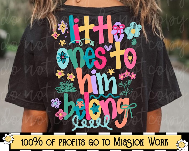 Op de afbeelding: Zwart T-shirt met de tekst "Little Ones To Him Belong" in kleurrijke, speelse letters. Het ontwerp bevat bloemen- en steraccenten. De onderkant van het shirt heeft de tekst "100% OF PROFITS GO TO MISSION WORK".