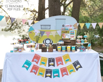 May include: A white table with a white tablecloth and a colorful banner that says "Happy Birthday" with a camper van design. The table is decorated with a variety of party supplies, including cupcakes, candy, and a cardboard cutout of a camper van.