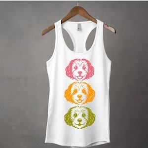 May include: White tank top with three colourful dog faces printed on the front. The dogs are facing forward and have a happy expression. The top of the tank top is a racerback style.