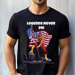 May include: Black t-shirt featuring a muscular figure holding an American flag. The figure is wearing red and yellow attire. The text "LEGENDS NEVER DIE" is printed above the graphic.