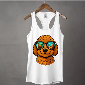 May include: White tank top featuring a cartoon dog with orange fur wearing sunglasses. The sunglasses reflect a beach scene with a burger, hot dog, and palm trees. The tank top has a racerback design.