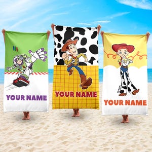 May include: Three beach towels featuring characters from the animated film Toy Story. One towel has Buzz Lightyear on a green background, another has Woody on a yellow background, and the third has Jessie on a yellow background. Each towel has the text "YOUR NAME" at the bottom.