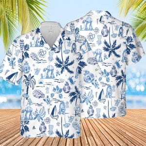 May include: White button-up shirt featuring a blue tropical and Star Wars-themed pattern. The design includes palm trees, sailboats, and Star Wars characters. The shirt has short sleeves and a V-neck collar.