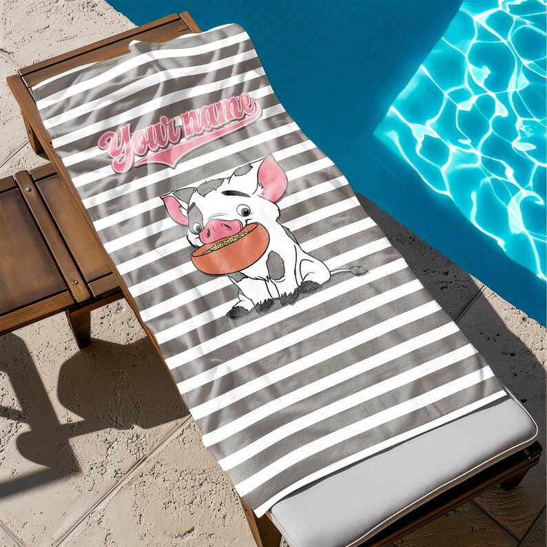 May include: A gray and white striped beach towel with a cartoon pig wearing a pink shirt and holding a bowl of food. The text "Your name" is written in pink on the towel.
