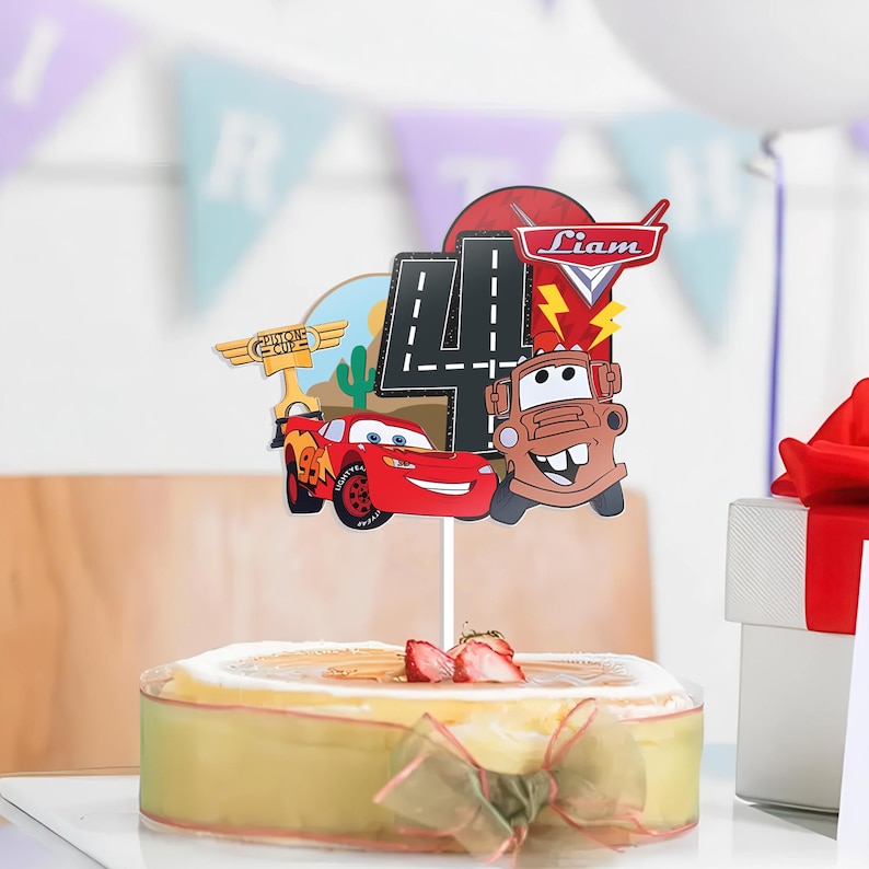 May include: A cake topper featuring Lightning McQueen and Mater from the Cars movie, with a large number 4 and the name "Liam". The topper is placed on a cake decorated with strawberries and a ribbon.