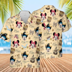 May include: A beige button-up shirt with a repeating pattern of Mickey and Minnie Mouse in pirate outfits, treasure chests, bows, and swords. The shirt has a classic collar and short sleeves. The words "Mickey Mouse" and "Minnie Mouse" are also printed.