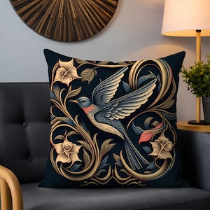 Könnte beinhalten: Ein dekoratives Kissen mit einem blauen Vogel, der durch ein goldenes und grünes Blumenmuster auf dunkelblauem Hintergrund fliegt.