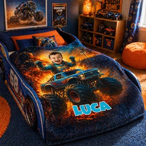 May include: A blue race car-shaped bed frame featuring a plush blanket printed with a child driving a monster truck amidst flames. The blanket displays the name LUCA in large blue letters. The bed includes a matching pillow with a monster truck graphic.
