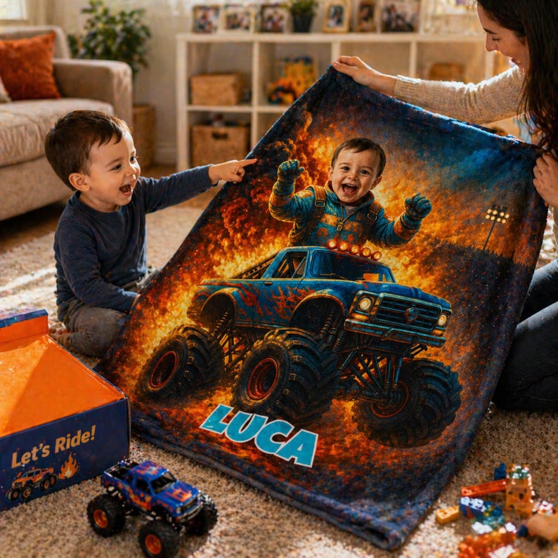 May include: A soft blanket featuring a custom graphic of a child driving a blue monster truck amidst flames, with the name LUCA printed in large blue letters. The design includes a vibrant orange and yellow fire background and a detailed truck.