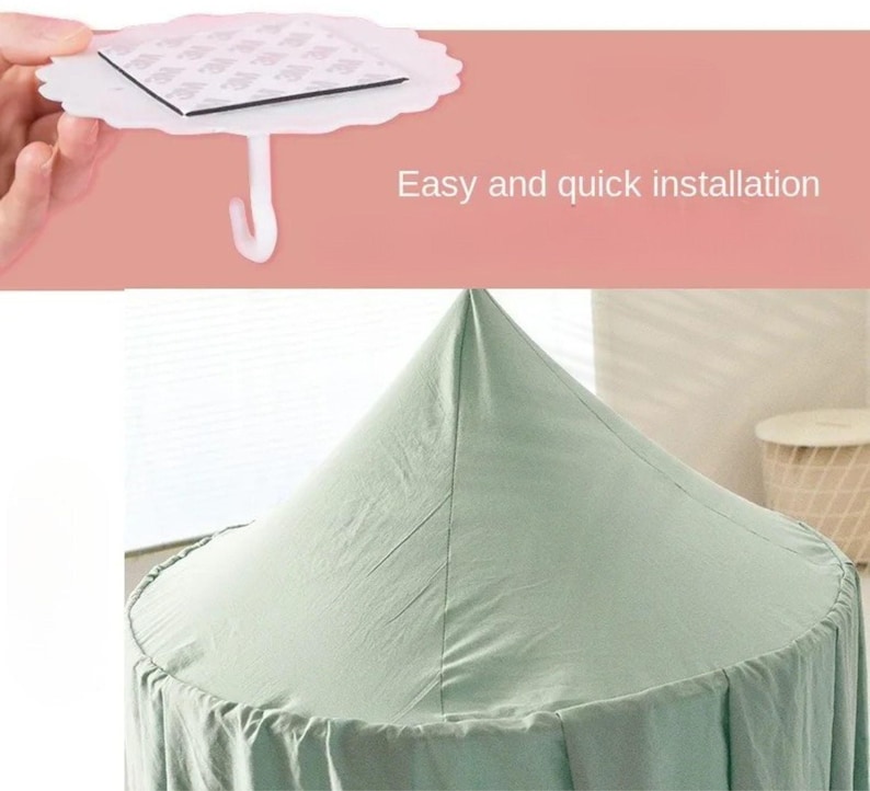 May include: A white, scalloped-edge adhesive hook with a square adhesive pad and a curved hook, held by a hand. The text "Easy and quick installation" is displayed. Below is a light green canopy.
