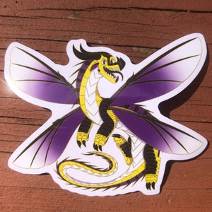 May include: A sticker of a purple and yellow dragon with wings spread wide. The dragon has a white underbelly and black markings. The dragon is in a flying pose with its wings spread wide.