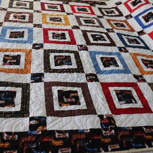 May include: A quilt with a patchwork design featuring squares of different colors and patterns. The squares are arranged in a grid pattern, and the quilt is quilted with a swirling design. The quilt is made of cotton fabric and is in good condition.