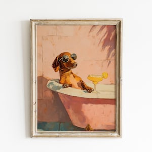 May include: A framed print of a dachshund wearing sunglasses, lounging in a bathtub with a cocktail. The artwork has a vintage style with a pink and brown colour scheme. The dog is the central subject of the image.