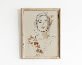May include: Framed art print featuring a minimalist line drawing of a woman with closed eyes. The artwork is in shades of brown and black, with floral accents. The frame is a light, natural wood color, adding a touch of warmth to the piece.