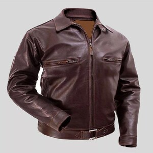 Puede incluir: Una chaqueta de cuero marrón con cierre de cremallera y cinturón en la cintura. La chaqueta tiene dos bolsillos en el pecho y dos bolsillos en la parte delantera inferior.