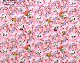 Può includere: Tessuto rosa con un motivo ripetuto di Snoopy, Charlie Brown e altri personaggi dei Peanuts. Il design include elementi floreali e arcobaleno. Il testo "Vintage Peanuts" è visibile in alto a sinistra.
