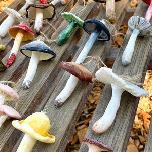 mushroom ornaments in many colors laying down on brown bench, sparkling