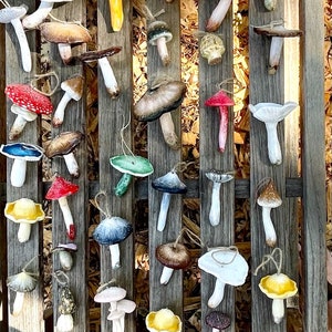 mushroom ornaments in many colors laying down on brown bench, sparkling