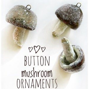 three brown clay glittery mushroom ornaments laying on white background