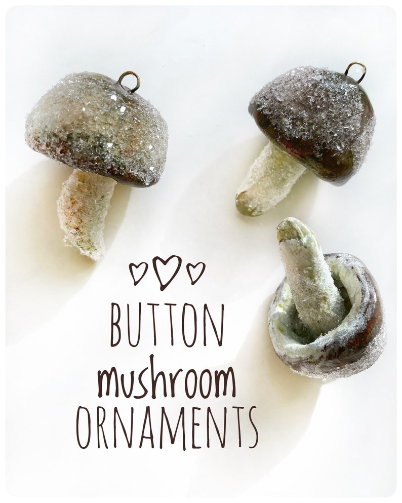 three brown clay glittery mushroom ornaments laying on white background