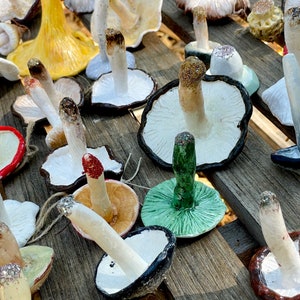 mushroom ornaments upside down in many colors laying down on brown bench, sparkling