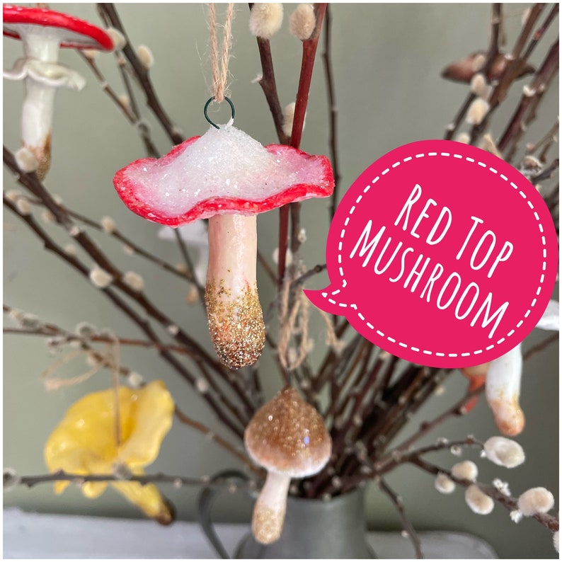 four clay glittery mushroom ornament  hanging on branches, bright pink bubble "red mushroom"