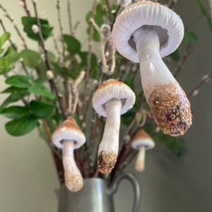 3 brown and white mushroom ornament hanging from tree