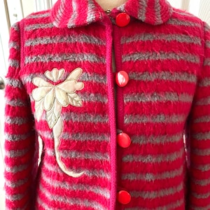 May include: A red and gray striped wool jacket with a floral embroidery design and red buttons.