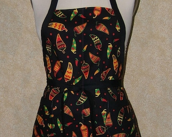 Pode incluir: Avental preto com um padrão colorido de pimentas. O avental tem um babete, laços na cintura e dois bolsos. As pimentas são vermelhas, amarelas, verdes e laranjas, com vários padrões. O avental é exibido num manequim.