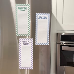 May include: Three rectangular notepads with lined paper and checkered borders in green, blue, and purple. The notepads have text that reads "Stuff That Won't Buy Itself", "Buy This, Or Starve", and "Things I'll Forget Anyway".