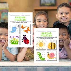 Könnte beinhalten: Kinder lächeln und halten Frühlingspuzzles in die Kamera. Die Puzzles zeigen farbenfrohe Illustrationen eines blauen Vogels, Schmetterlingen, eines Marienkäfers, einer Sonne, einer Biene, einer Raupe und einer Schnecke. Der Text auf den Blättern lautet "Spring Puzzles".